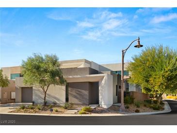 Modern home featuring clean lines, neutral tones, and desert landscaping for a sleek, contemporary look at 21 Highland Cove Ln, Henderson, NV 89011