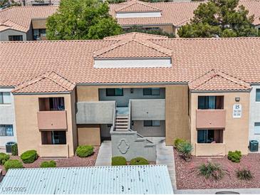 Two-story condo building with tile roof, neutral paint, and simple landscaping at 3151 Soaring Gulls Dr # 1062, Las Vegas, NV 89128