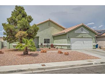 Charming single-story home featuring desert landscaping, attached garage, and neutral toned stucco exterior at 4318 Scarlet Vista Ct, North Las Vegas, NV 89031