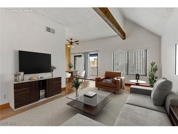 Bright living room features modern furnishings, neutral tones, and a sliding glass door at 4391 Gannet Cir # 16, Las Vegas, NV 89103