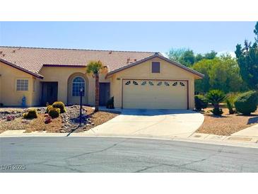 Charming single-story home featuring a two-car garage, desert landscaping, and a well-manicured lawn at 4833 Lawnwood Ct, Las Vegas, NV 89130