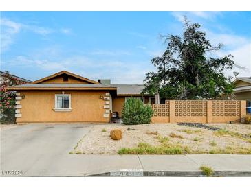 Tan single-story home showing the front with low-maintenance yard and concrete block fence at 5900 Fawn Ave, Las Vegas, NV 89107