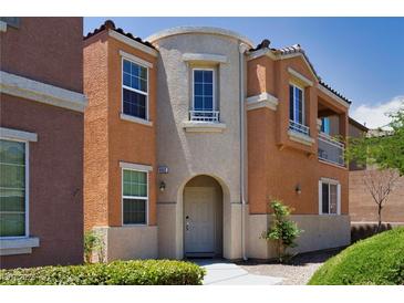 Attractive two-story home with a neutral color scheme, arched entryway, and desert landscaping at 9032 Retro Ct, Las Vegas, NV 89149