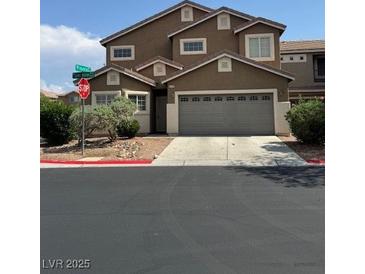 Two-story home with a two-car garage, neutral paint and desert landscaping at 9145 Sunken Meadow Ave, Las Vegas, NV 89178