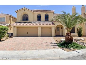 Charming two-story home with a well-maintained lawn, mature palm tree, and a two-car garage at 10052 Baystone St, Las Vegas, NV 89141