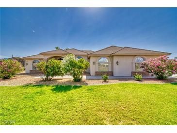 Charming single-story home with a well-manicured lawn and colorful flowering bushes at 2851 Winchester Ave, Pahrump, NV 89048
