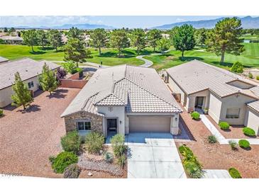 Single-story home featuring desert landscaping, a stone facade, and an attached two-car garage, set on a golf course at 5235 E La Campana Dr, Pahrump, NV 89061