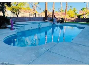 Sparkling pool and spa offer a relaxing outdoor oasis with lush landscaping at 5568 Yellow Ash St, Las Vegas, NV 89118