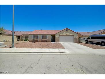 Single story home with neutral colors, a well-kept rock yard, and a two car garage at 5730 Coleman St, North Las Vegas, NV 89031