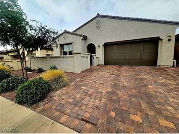Charming single-story home with a well-manicured front yard and brick driveway at 782 Omaggio Pl, Henderson, NV 89011