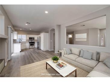 Bright living room features an open floor plan with a view of the kitchen and neutral color palette at 7836 Pinnochio Ave, Las Vegas, NV 89131
