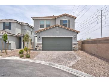 Two-story home with gray stucco, two-car garage and brick paver driveway in a suburban neighborhood at 10292 Fragrant Apple Ct, Las Vegas, NV 89141