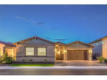 Charming single-story home featuring a two-car garage, desert landscaping, and a welcoming facade during twilight hours at 326 Beethoven Ridge Dr, Henderson, NV 89011