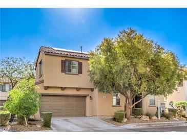 Charming two-story home featuring a two-car garage, desert landscaping, and a shade tree at 5232 Pendergrass St, North Las Vegas, NV 89081