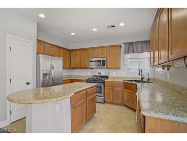 Well-lit kitchen featuring stainless steel appliances, granite counters, and wood cabinets at 9190 Wine Cellar Ave, Las Vegas, NV 89148