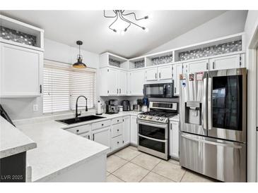 Bright kitchen with white cabinets, stainless steel appliances, and modern lighting fixtures at 9333 Jumpin Juniper Ave, Las Vegas, NV 89129