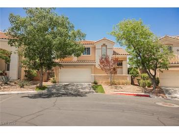 Charming two-story home with a well-maintained front yard and a two-car garage on a sunny day at 2057 Wandering Doe Ln, Las Vegas, NV 89134