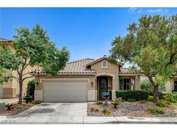 Charming single-story home featuring a two-car garage, tile roof, and landscaped front yard with mature trees at 2958 Lapis Beach Dr, Las Vegas, NV 89117