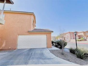 Attached two-car garage with extended driveway and desert landscaping against blue sky at 3542 Harbor Tides St, Las Vegas, NV 89147
