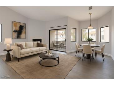 Bright living room featuring modern furnishings, fireplace and balcony access overlooking the community at 5032 S Rainbow Blvd # 206, Las Vegas, NV 89118