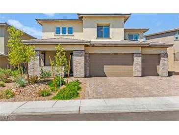 Beautiful two-story home with stone accents, three-car garage, and well-maintained landscaping at 767 Tallgrass St, Las Vegas, NV 89138