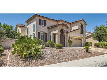 Inviting two-story stucco home with a tile roof, desert landscaping, and a private gated entrance at 1667 Sabatini Dr, Henderson, NV 89052