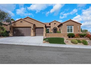 Charming single story home with a terracotta roof, three car garage, and well manicured desert landscaping at 2175 Sandstone Cliffs Dr, Henderson, NV 89044