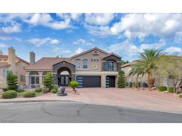 Stunning two-story home with stone accents, tile roof, and a well-manicured front yard with a brick driveway at 4108 Royal Scots Ave, Las Vegas, NV 89141