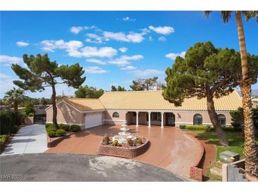 Spacious single-story home with a circular driveway, mature trees, and a charming fountain at 5829 W Patrick Ln, Las Vegas, NV 89118