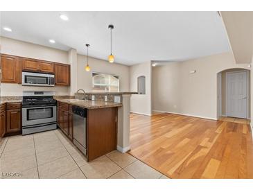 Well-lit kitchen featuring wood cabinets and stainless steel appliances with tile floors at 8409 Running Deer Ave # 203, Las Vegas, NV 89145