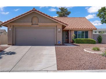 Charming single-story home featuring a well-maintained front yard and a two-car garage at 1219 Heather Oaks Way, North Las Vegas, NV 89031