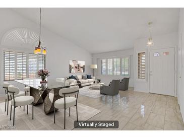 Bright living room with dining area, tile floors, modern furniture, and natural light at 1219 Heather Oaks Way, North Las Vegas, NV 89031