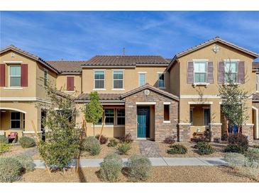 Beautiful townhome with stone accents, inviting landscaping and a stylish teal-colored front door at 2878 Via Firenze, Henderson, NV 89044