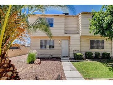 Charming two-story home with a well-maintained front yard featuring desert landscaping and mature palm trees at 4693 Mill Valley Dr, Las Vegas, NV 89120
