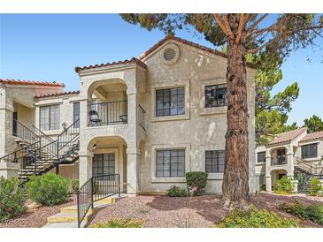 Charming two-story condo with stucco siding, balcony, and mature tree at 4718 Nara Vista Way # 104, Las Vegas, NV 89103