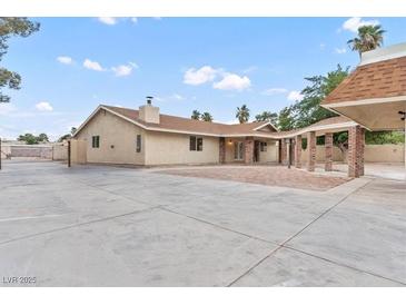 Spacious single-story home featuring a large concrete patio, brick accents, and a welcoming covered area at 4805 Jay Ave, Las Vegas, NV 89130