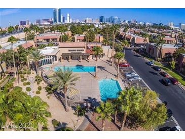 Aerial view of a beautiful community pool surrounded by lush landscaping and palm trees at 5185 Indian River Dr # 223, Las Vegas, NV 89103