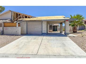 Exterior view of a distressed single-Gathering home with damaged roof and peeling paint at 6723 Oak Valley Dr, Las Vegas, NV 89103