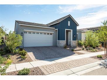 Charming single-story home featuring a brick driveway, a two-car garage, and a well-manicured front yard at 832 Canonbury St, Henderson, NV 89011