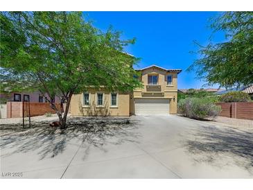 Two-story home featuring a two-car garage, desert landscaping, and mature shade trees at , North Las Vegas, NV 89084