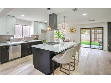 Modern kitchen boasts stainless steel appliances, a large island, and sleek black and white cabinetry at 10009 Coral Sands Dr, Las Vegas, NV 89117