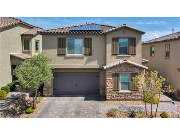 Two-story home boasts a neutral color palette, stone accents, and a two-car garage with an attractive brick paver driveway at 10116 Skye Castle Dr, Las Vegas, NV 89166