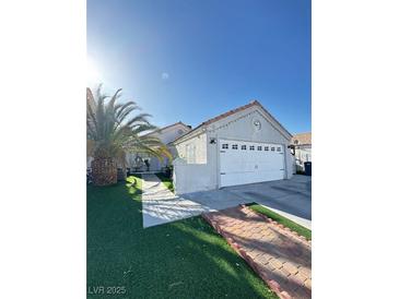 Charming single-story home with desert landscaping, a spacious driveway, and a two-car garage at 1505 Lilac Breeze Cir, Las Vegas, NV 89108