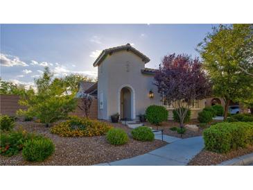 Charming single-story home with arched entry and well-manicured landscaping with blooming flowers at 1869 Bronze Patina St, Henderson, NV 89044