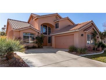 Charming two-story home featuring an attached garage, tile roof, arched windows, and well-maintained landscaping at 2143 Vista Famosa Ct, Las Vegas, NV 89123