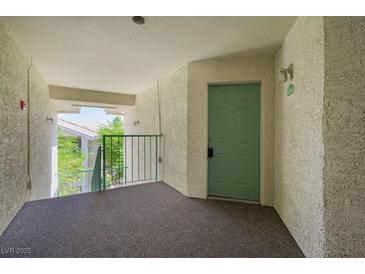 Condo entrance featuring a light green door with unit number, and view of trees from the hall at 3550 Bay Sands Dr # 3006, Laughlin, NV 89029