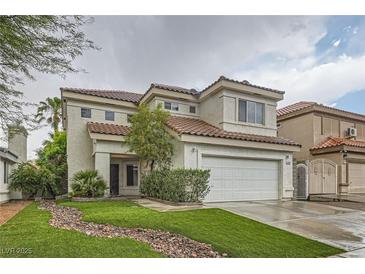 Charming two-story home with a well-manicured lawn and a two-car garage with a new roof and green grass at 7267 W Mesa Vista Ave, Las Vegas, NV 89113