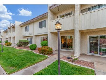 Charming two-story condo with well-manicured lawn, mature landscaping, and a welcoming entryway at 768 Lawrence Dr, Henderson, NV 89015