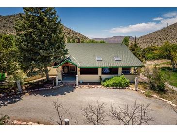 Charming bungalow-style house with a well-maintained yard and a gravel driveway surrounded by nature at 18480 State Hwy 160, Las Vegas, NV 89161
