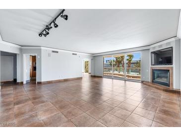 Expansive living room featuring tile floors, a fireplace, and a wall of windows with access to a private balcony at 2857 Paradise Rd # 301, Las Vegas, NV 89109